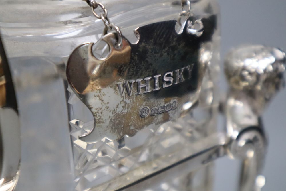 An Edwardian plated decanter stand, fitted three square cut glass decanters and three silver bottle labels, 36cm wide